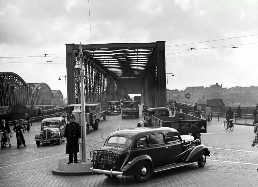 black and white photo of vehicles on a bridge